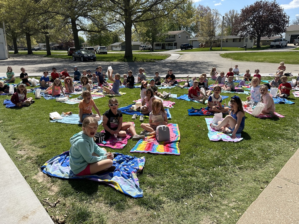 picture of students sitting on towels on the lawn eating lunch
