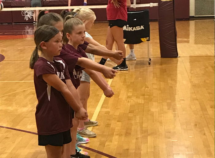 Girls in a line practicing volleyball